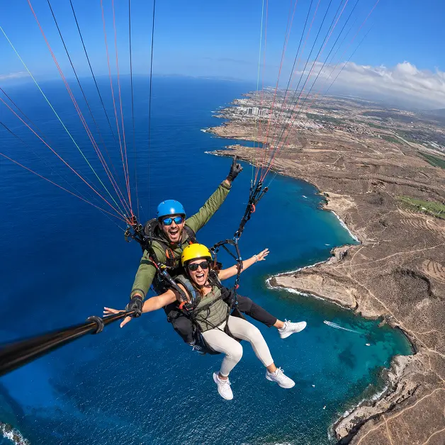 Paragliding flight over Tenerife coastline with panoramic ocean views