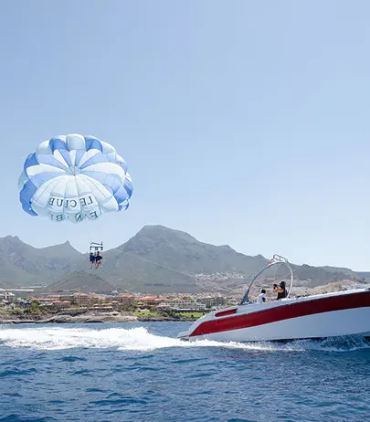 Water sports action off the coast of Tenerife, including jet skis and inflatable rides.